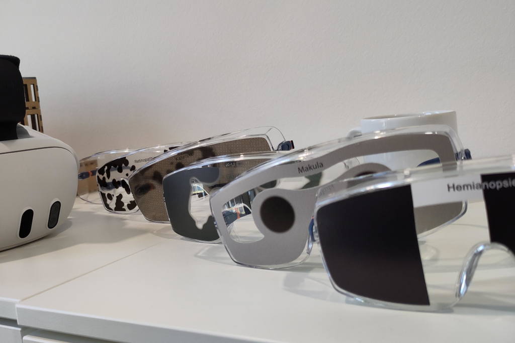6 Schutzbrillen in einer Reihe mit abgeklebten Regionen und Aufschriften: Makula, Katarakt, Hermianopsi- und eine VR-Brille